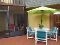 A cozy patio area with umbrella providing shade and comfortable outdoor seating at 116 Cedar Dunes Dr, New Smyrna Beach, FL 32169