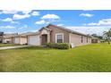 House exterior showing the side of the home, with a well maintained lawn and landscaping at 230 Oak Branch Dr, Edgewater, FL 32141
