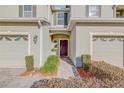 Townhome entrance with walkway, landscaping, and two-car garage at 104 Kelly Thomas Way, Daytona Beach, FL 32124