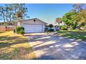 White brick home with a driveway and large grassy yard at 1120 Marcel St, New Smyrna Beach, FL 32168