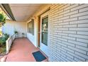 Brick front porch with a white door and small planter at 1120 Marcel St, New Smyrna Beach, FL 32168