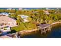 Aerial view of waterfront property with boat lift and lush landscaping at 1324 N Peninsula Ave, New Smyrna Beach, FL 32169