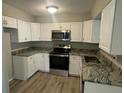 Modern kitchen featuring stainless steel appliances, granite countertops, and ample white cabinetry at 1500 Wildrose Ln, Daytona Beach, FL 32117