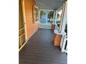 Inviting front porch with wooden flooring and orange walls at 202 S Myrtle Ave, New Smyrna Beach, FL 32168