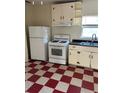 Retro kitchen with white appliances and red checkered floor at 202 S Myrtle Ave, New Smyrna Beach, FL 32168