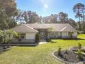 House exterior with stone accents and manicured lawn at 2322 Melonie Trl, New Smyrna Beach, FL 32168