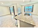 Modern kitchen with granite island, stainless steel appliances, and pond view at 3035 Meleto Blvd, New Smyrna Beach, FL 32168