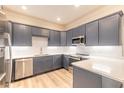 Modern kitchen with gray cabinets, quartz countertops, and stainless steel appliances at 3067 Isles Way, New Smyrna Beach, FL 32168