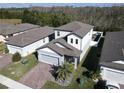 Aerial view of a house with gray roof and paver driveway in a neighborhood at 3133 Crab Trap Dr, New Smyrna Beach, FL 32168