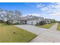 Three-car garage home with paver driveway and lush landscaping at 3309 Modena Way, New Smyrna Beach, FL 32168