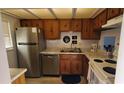 Cozy kitchen featuring wood cabinets, stainless steel appliances, and granite countertops at 4155 S Atlantic Ave # 5090, New Smyrna Beach, FL 32169