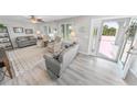 Bright living room with gray sofas, wood-look floors, and large windows at 4367 S Peninsula Dr, Ponce Inlet, FL 32127