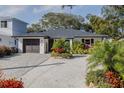 Single story home with a gray roof, white exterior, and a paver driveway at 814 E 20Th Ave, New Smyrna Beach, FL 32169