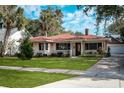 One-story house with red tile roof, green lawn, and a driveway at 1207 Magnolia St, New Smyrna Beach, FL 32168