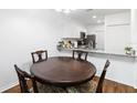 Round wooden dining table with four chairs, kitchen with granite countertop visible at 122 Turnbull Villas Cir, New Smyrna Beach, FL 32168