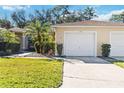 Front view of a single-story home with a white garage door and landscaped yard at 122 Turnbull Villas Cir, New Smyrna Beach, FL 32168