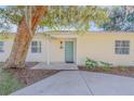 Front entrance of a light yellow house with a teal door and landscaping at 142 Jean Francis Ln, Port Orange, FL 32127