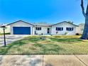 Charming home with a blue garage door, a manicured lawn, and stylish black shutters at 2101 Oriole Ln, South Daytona, FL 32119