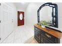 Bright entryway with tiled floor, dark wood console table, and mirror at 216 Fairgreen Ave, New Smyrna Beach, FL 32168