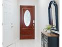 Front entry with wood door and oval stained glass window at 216 Fairgreen Ave, New Smyrna Beach, FL 32168