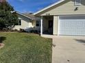 House exterior showcasing a covered porch, attached garage, and manicured lawn at 216 Fairgreen Ave, New Smyrna Beach, FL 32168