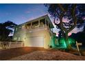 Two-story house with white garage and outdoor lighting at 221 Columbus Ave, New Smyrna Beach, FL 32169