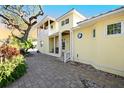 Yellow house with paver walkway and lush landscaping at 221 Columbus Ave, New Smyrna Beach, FL 32169