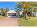 Charming house featuring a paver driveway and mature palm trees at 258 Navajo Dr, Oak Hill, FL 32759