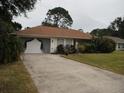 Front view of a single-story house with a driveway and landscaping at 2715 Banyan Dr, Edgewater, FL 32141