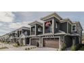 Row of townhouses with gray exterior, brown garage doors, and American flags at 2870 Isles Way, New Smyrna Beach, FL 32168