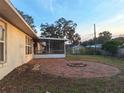 Spacious brick patio with a fire pit, surrounded by a well-maintained lawn at 3020 Kumquat Dr, Edgewater, FL 32141