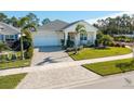 Aerial view of a one-story house with a paved driveway and manicured lawn at 3037 Borassus Dr, New Smyrna Beach, FL 32168