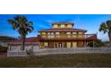 Two-story house with red metal roof, white fence, and palm trees at 3726 S Atlantic Ave, New Smyrna Beach, FL 32169