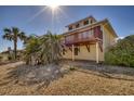 Back view of beach house showing patio and tropical landscaping at 3726 S Atlantic Ave, New Smyrna Beach, FL 32169