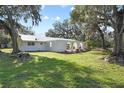 White home with a green metal roof and lush landscaping at 384 W Ariel Rd, Edgewater, FL 32141