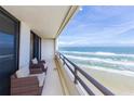 Balcony with partial ocean view and wicker chairs at 3855 S Atlantic Ave # 1105, Daytona Beach Shores, FL 32118