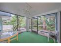 Screened porch with table and chairs, overlooking trees at 4150 S Atlantic Ave # 112C, New Smyrna Beach, FL 32169