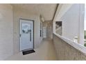 Hallway showing the building access, a white door with decorative glass, and stairs at 432 Bouchelle Dr # 403, New Smyrna Beach, FL 32169