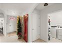Bright hallway with tile flooring leading to a laundry room and front door at 5340 Bear Corn Run, Port Orange, FL 32128