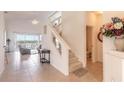 Bright entryway with stairs, tile floors, and a view into the living room at 5727 Riverside Dr, Port Orange, FL 32127