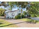 Side view of a charming light blue house nestled amongst lush greenery at 636 Faulkner St, New Smyrna Beach, FL 32168