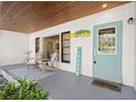 Inviting front porch with wooden chairs and a light teal door at 636 Faulkner St, New Smyrna Beach, FL 32168