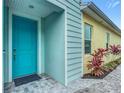 Charming teal front door and walkway leading to a light blue home at 667 Margaritaville Ave, Daytona Beach, FL 32124