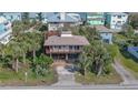 Aerial view of beach house with large deck and tropical landscaping at 6911 Turtlemound Rd, New Smyrna Beach, FL 32169