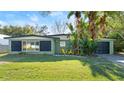 Green house exterior with black shutters, yellow chairs, and a well-maintained lawn at 729 N Flamingo Dr, Daytona Beach, FL 32117