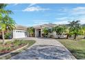 Single-story home with tile roof, palm trees, and a brick driveway at 987 Mori Ct, Port Orange, FL 32127