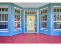 Inviting front door with a glass oval and sidelights, leading to a red porch at 1004 Flying M Ct, Edgewater, FL 32132