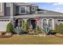 Gray house with a fountain, lush landscaping, and a welcoming front porch at 1409 Arbitus Cir, Oviedo, FL 32765