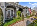 Relaxing front porch with rocking chairs, brick walkway, and beautiful landscaping at 1409 Arbitus Cir, Oviedo, FL 32765