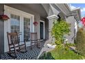 Charming front porch with rocking chairs, a patterned rug, and hanging flower baskets at 1409 Arbitus Cir, Oviedo, FL 32765